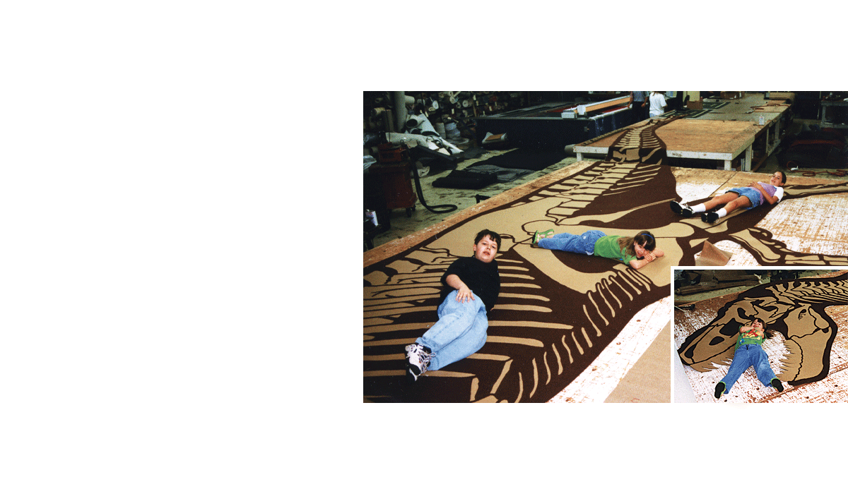 Custom brown and tan inlay for carpet in a museum of a tyrannosaurus rex skeleton with kids